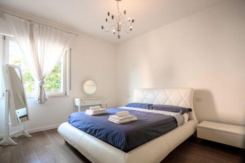 Un dormitorio con una cama con sábanas azules y una lámpara de araña. en L'OASI DELLA PACE - Confortevole e vicino a tutto en Chiaravalle