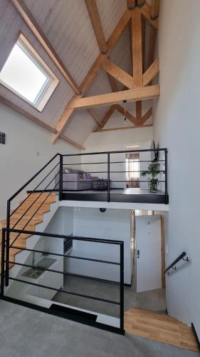 a loft with a staircase and a vaulted ceiling at B&B Rossella App 3 in Roeselare
