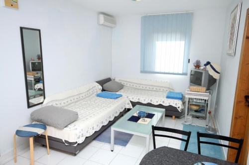 a room with two beds and a table and chairs at Apartments by the sea Kosljun, Pag - 3321 in Košljun