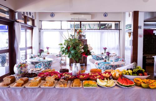 a table with a bunch of different types of food at Barra do Piuva Porto Hotel in Ilhabela