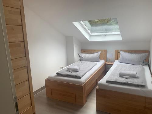 two beds in a small room with a skylight at Ferienwohnung *Am Bronnwiesle* in Deggingen
