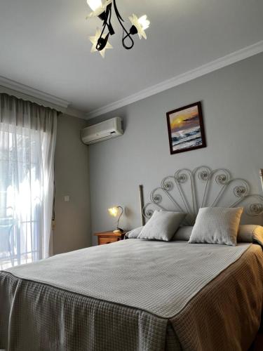 una camera da letto con un grande letto e un copriletto bianco di Hotel Arco del Sol a Colmenar
