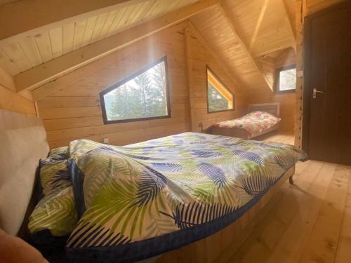 uma cama num pequeno quarto num chalé de madeira em Villat Shkreli Relax em Pec