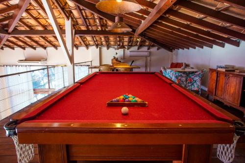 a pool table with a red cover in a room at Barra do Piuva Porto Hotel in Ilhabela