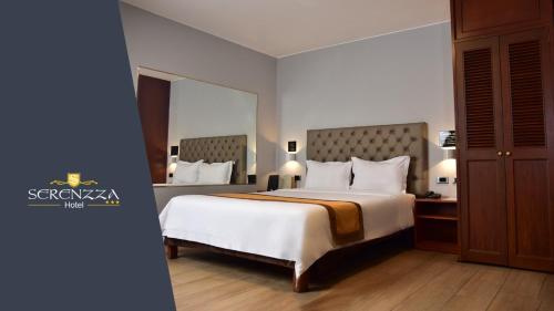 a bedroom with a large bed and a large mirror at Serenzza Hotel in Lima
