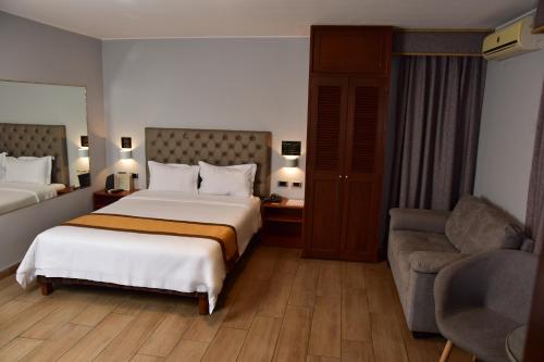 una camera d'albergo con letto e divano di Serenzza Hotel a Lima