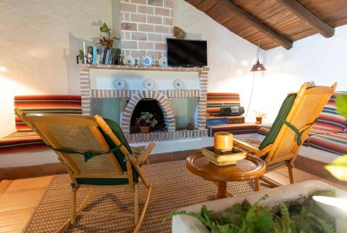 un soggiorno con camino e sedie di Casa Rural La Capellania a Granadilla de Abona