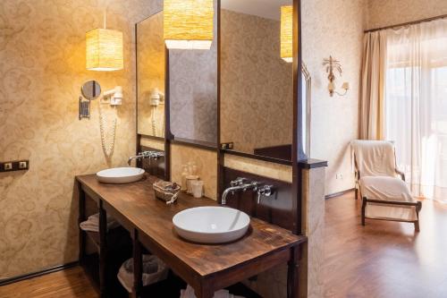 a bathroom with two sinks and a large mirror at Posada Real Restaurante El Linar Del Zaire in Burgohondo