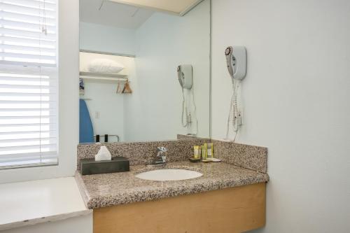 a bathroom counter with a sink and a phone at Pacifica Beach Hotel in Pacifica