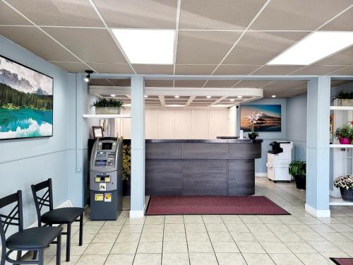 an office lobby with a cash register and chairs at Canadian Motor Inn in Grande Prairie