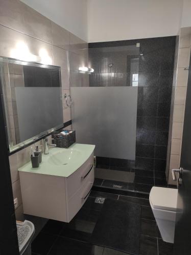 bagno con lavandino, specchio e doccia di Nikilein's House, διαμέρισμα 150μ απο την παραλία a Roda