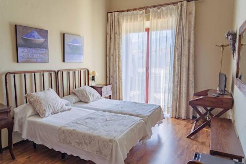 a bedroom with a bed and a large window at Posada Real Restaurante El Linar Del Zaire in Burgohondo