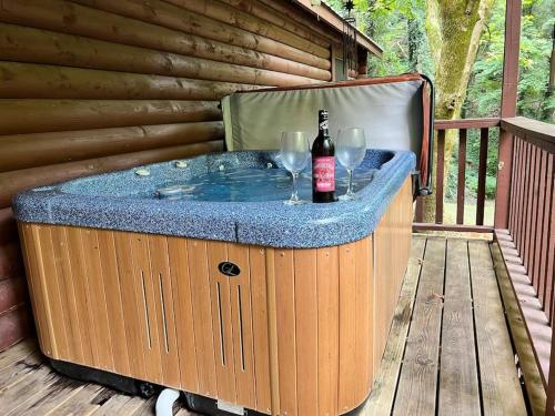 a hot tub with a bottle of wine and glasses at Bear Nakid in Pigeon Forge