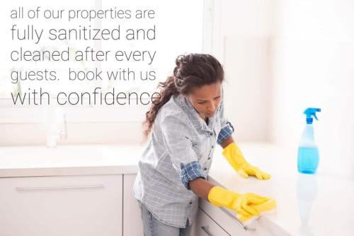 a woman is cleaning a counter in a kitchen at Bright Modern Home - King Bed - Free Parking - Fireplace - Fast Wi-Fi - Free Netflix in Edmonton