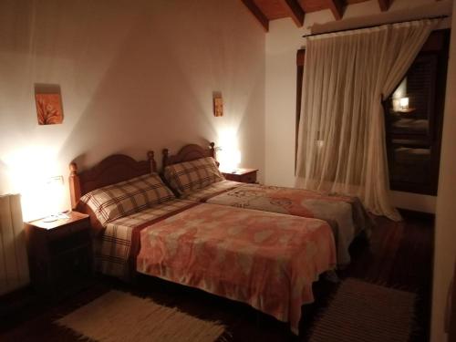1 dormitorio con 1 cama con 2 lámparas y una ventana en Casa viccoca, en Póo