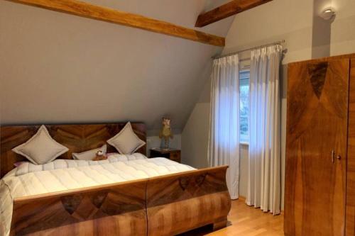 a bedroom with a large bed with a wooden headboard at House MayFa in Riedseltz