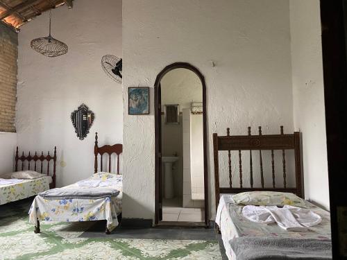 um quarto com duas camas e uma porta aberta em Rio Natureza apart 120 no Rio de Janeiro