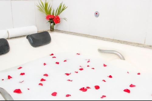 uma banheira com borboletas vermelhas no chão em Garça Branca Praia Hotel em Porto Seguro