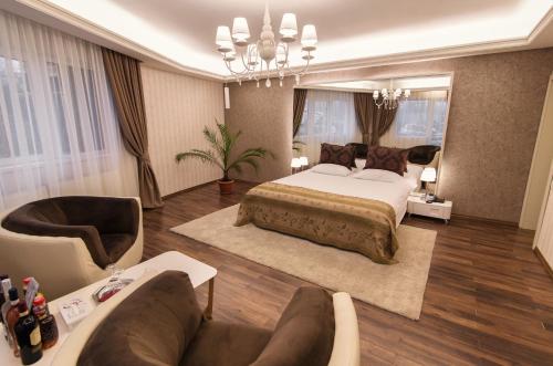 a bedroom with a bed and a chair and a couch at Hotel Belvedere in Braşov