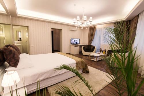 a bedroom with a large bed and a living room at Hotel Belvedere in Braşov