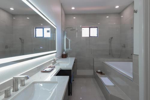 ein weißes Badezimmer mit zwei Waschbecken und einer Badewanne in der Unterkunft The Bungalows on Shary in McAllen