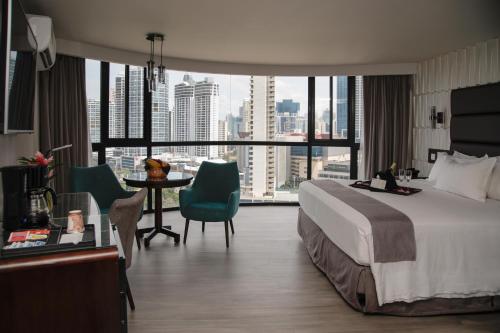 a hotel room with a bed and a table with chairs at Plaza Paitilla Inn in Panama City