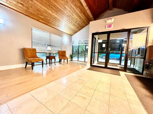 eine leere Lobby mit Stühlen und ein Ausstiegszeichen an der Tür in der Unterkunft Bayou Inn & Suites in Bayou La Batre