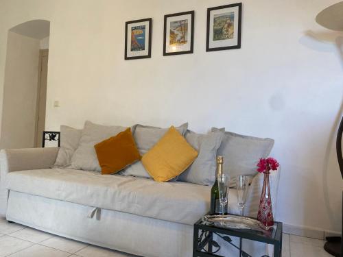 a living room with a white couch with yellow pillows at Casa Eugénie l'appartement de tante Madeleine vue sur les montagnes in Venaco