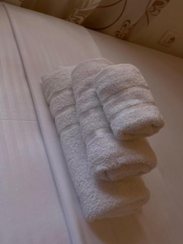 a towel on the side of a bed at Skrapari Studio Apartment in Çorovodë