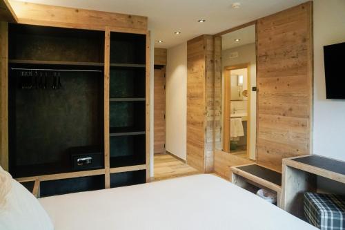 a bedroom with wooden walls and a bed and a tv at Sci Sport rooms & suites in Bormio