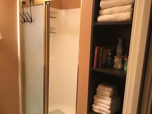 un bagno con porta doccia in vetro e asciugamani di Adorable Garden Suite a Rockport