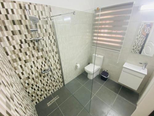 a bathroom with a toilet and a glass shower at Secret garden 03 in Mağusa