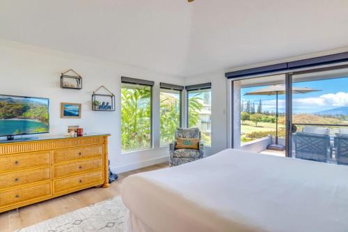 a bedroom with a bed and a tv and windows at K B M Resorts- KGV-19P2 Beautifully designed two bed two bath Golf Villa with breath taking acqua marine views in the heart of Kapalua in Kapalua
