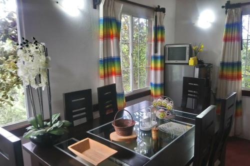 comedor con mesa y cortina de arco iris en Cabaña con Bañera en Puesta de Sol en El Pacífico