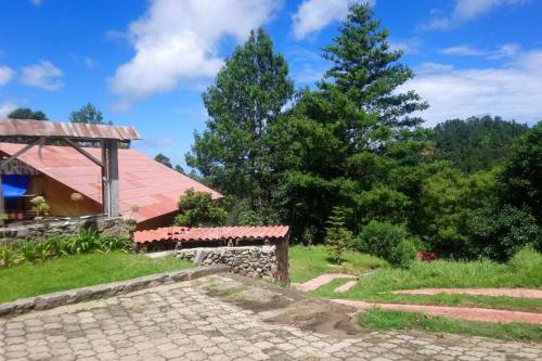 El Pacífico的住宿－Cabaña con Bañera en Puesta de Sol，一座有长凳和树木的建筑