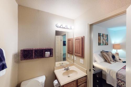 a small bathroom with a sink and a bed at Water Wheel Resort Condo BLDGI 101 in New Braunfels