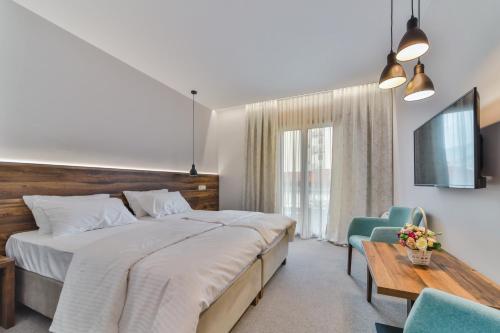a bedroom with a large bed and a table and chairs at Hotel Vladimir in Budva