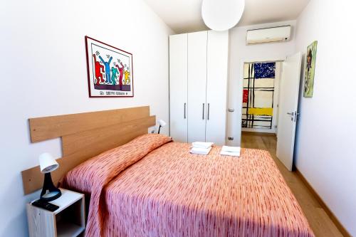 a bedroom with a large bed with a orange blanket at Farini Apartment in Milan