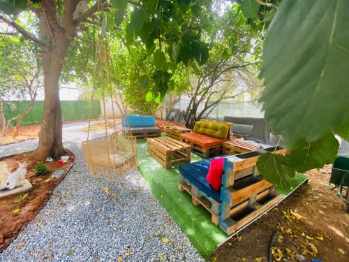 a patio with a couch and chairs under a tree at Secret Garden Guest House 04 in Famagusta