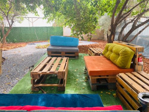 a group of benches and chairs on the grass at Secret Garden Guest House 04 in Mağusa