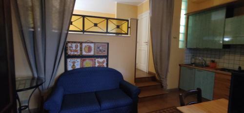 a living room with a blue chair and a kitchen at Life Hotels Residence dei Baroni in Siracusa