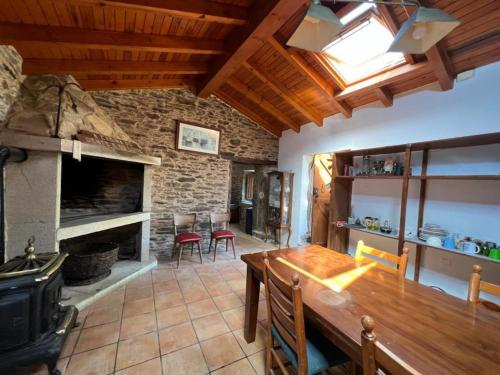 a living room with a wooden table and a fireplace at Casal de Pedra in Santa Irene