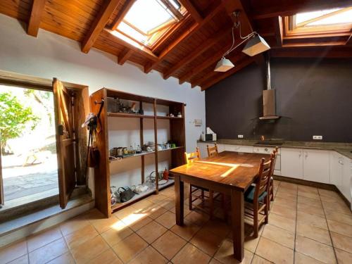Una cocina con una mesa de madera en una habitación. en Casal de Pedra, en Santa Irene