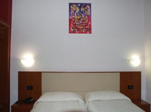 a bedroom with a bed and a painting above it at Eco Art Hotel Statuto in Turin