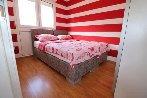 sypialnia z czerwoną i białą ścianą o paskach w obiekcie Tina w Puli