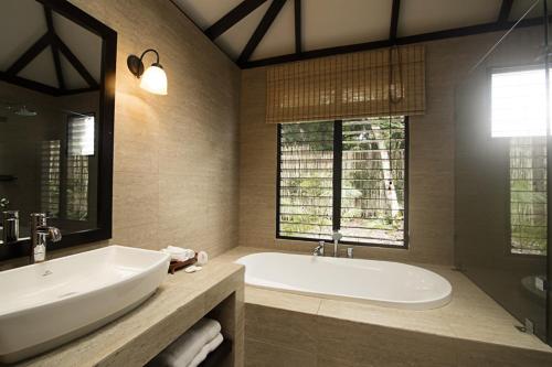 a large bathroom with a tub and a sink at Hotel Jungle Lodge Tikal in Tikal
