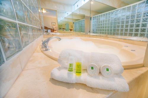 bagno con vasca, asciugamani e lavandino di Miraflores Colon Hotel a Lima