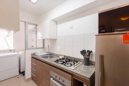 a kitchen with a sink and a stove top oven at ALU Apartments - Limit with Miraflores Panoramic City View in Lima