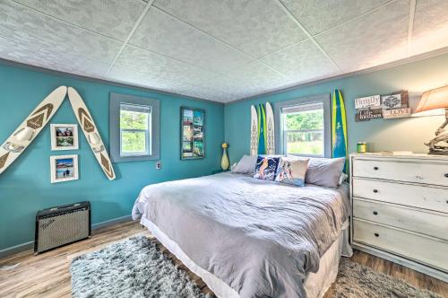 a bedroom with a bed with blue walls and windows at Riverfront Home with Dock about 6 Mi to Cheboygan! in Cheboygan