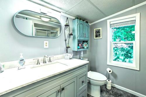 a bathroom with a sink and a toilet and a mirror at Riverfront Home with Dock about 6 Mi to Cheboygan! in Cheboygan